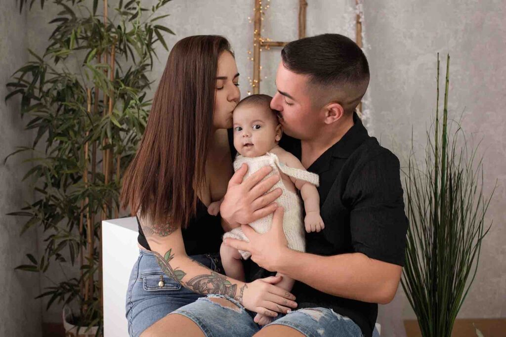 Familia con su bebé besandolo